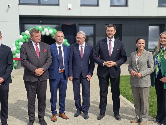 Grupa uczestników uroczystości przed wejściem do nowego budynku SDOO Nowe Linie.
